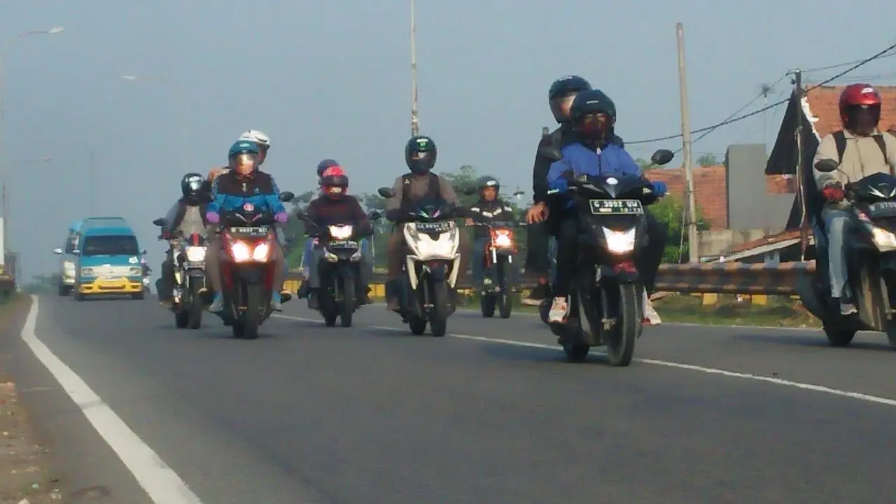 Pemudik bersepeda motor yang melintas di Karawang (Liputan6.com/Abramena)