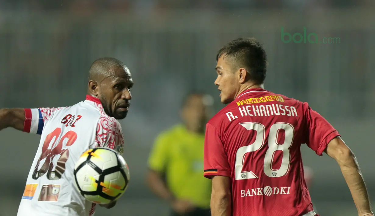 Pemain Persipura Jayapura, Boaz Solossa (kiri) saat berebut bola dengan pemain Persija, Rezaldi Hehanussa pada lanjutan Liga 1 Gojek bersama Bukalapak di Stadion Pakansari, Bogor, (25/5/2018).  Persija menang 2-0. (Bola.com/Nick Hanoatubun)