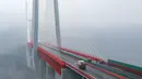 Kendaraan melintasi jembatan Beipanjiang di dekat Bijie, Provinsi Guizhou, barat daya China, 28 Desember 2016. Jembatanyang setara dengan ketinggian gedung 200 lantai itu itu menghubungkan provinsi Yunan dan Guizhou. (STR / AFP)