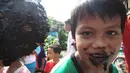 Meski pipi dan bibirnya terkena cat hitam, kegembiraan tampak diwajah bocah-bocah tersebut, Jakarta, Minggu (17/8/14). (Liputan6.com/Faizal Fanani) 