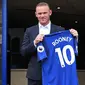 Penyerang baru Everton Wayne Rooney, memegang kostum tim barunya setelah konferensi pers di Goodison Park di Liverpool (10/8). Wayne Rooney dibeli Everton dari Manchester United. (AFP Photo/Paul Ellis)