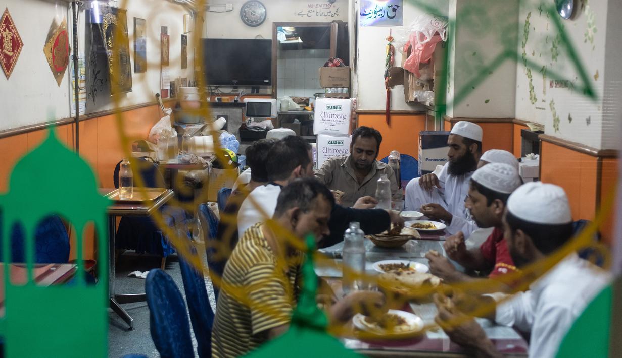 Para imigran Pakistan menikmati makanan sahur sebelum beribadah puasa di distrik Kwai Chung di Hong Kong (25/5/2019). Kwai Chung adalah daerah perkotaan di dalam Kota Baru Tsuen Wan di Wilayah Baru Hong Kong. (AFP Photo/Philip Fong)