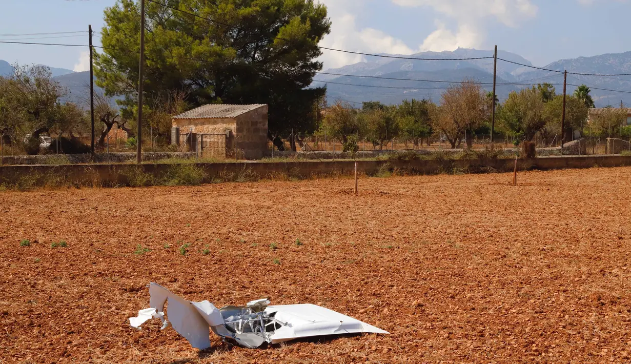 Puing-puing setelah helikopter dan pesawat kecil tabrakan terlihat di sebuah lapangan dekat Inca, Pulau Mallorca, Spanyol, Minggu (26/8/2019). Media setempat mengatakan pesawat ringan itu dinaiki dua orang, sementara helikopter membawa pasangan suami istri dan dua anak mereka. (STRINGER / AFP)