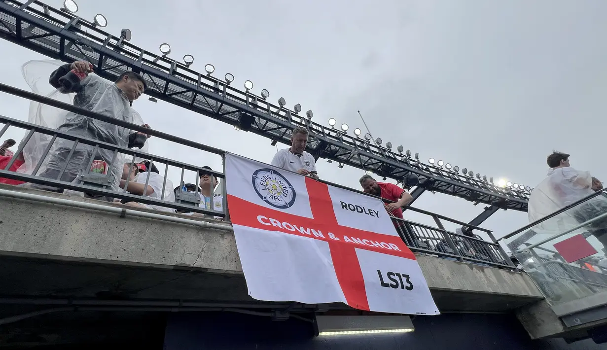Suporter Inggris memasang bendera di tribun Gillette Stadium, Foxborough, Boston, AS, Senin (23/6/2026). Beragam bendera klub dan daerah asal turut menghiasi tribun menjelang laga fase grup Piala Dunia 2026 antara Inggris melawan Ghana. (KLY Sports/Hery Kurniawan)