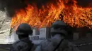 Petugas berjaga saat pembakaran ganja dan obat terlarag lainnya di kamp angkatan darat, Tijuana, Meksiko, (18/8/2015). 7 ton obat terlarang yang disita di Tijuana akan dibakar secara bersamaan di sembilan negara bagian di Meksiko. (REUTERS/Jorge Duenes)