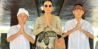 Kedua anak laki-lakinya memilih mengenakan kemeja putih lengan pendek dipadukan kain Bali yang serasi dengan ikat kepalanya. [@marcella.zalianty]