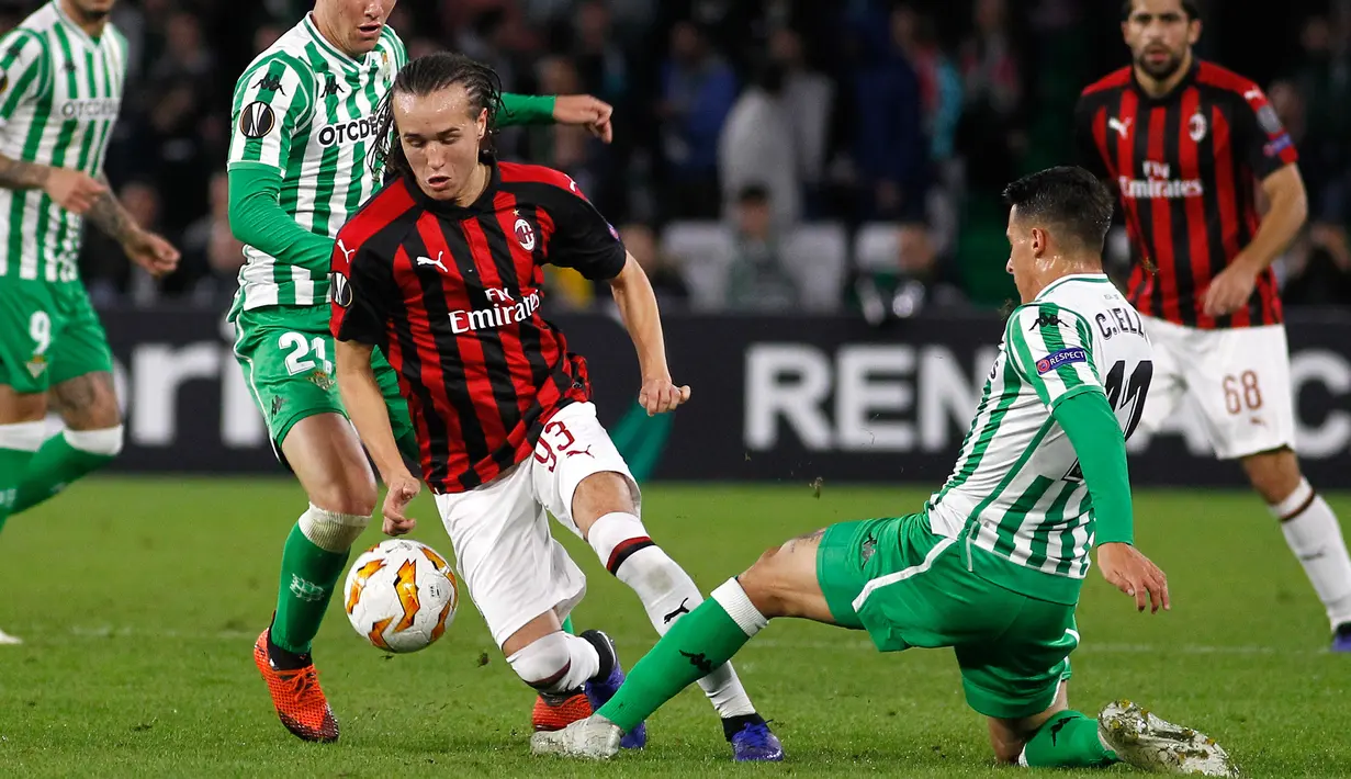 Gelandang AC Milan, Diego Laxalt berusaha melewati pemain Real Betis, Cristian Telli selama pertandingan grup F Liga Europa di stadion Benito Villamarin, Sevilla (8/11). Milan menahan imbang Betis 1-1. (AP Photo/Manuel Gomez)