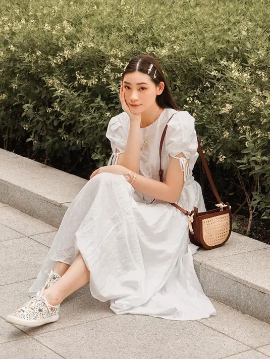 Penyanyi sekaligus model yang berusia 24 tahun ini tampil bak idol korea dengan pakaian serba putih. Rambutnya yang lurus menggunakan jepit rambut membuatnya tampak makin manis. Tas kecil berwarna cokelat melengkapi penampilan manisnya. (Liputan6.com/IG/@pattdevdex)