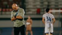 Pelatih Bali United, Johnny Jansen, tertunduk lesu setelah timnya hanya bermain imbang tanpa gol saat menjamu Persijap Jepara pada lanjutan BRI Super League 2025/2026, Sabtu (28/2/2026) malam WIB. (Bola.com/Alit Binawan)
