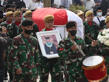 Prajurit TNI mengusung peti jenazah Almarhum Azyumardi Azra untuk dimakamkam di Taman Makam Pahlawan Kalibata, Jakarta, Selasa (20/9/2022). Anggota TNI berbaris sambil membawa foto almarhum semasa hidup. Mereka berdiri dibelakang peti jenazah berbalut bendera merah-putih. (Liputan6.com/Herman Zakharia)