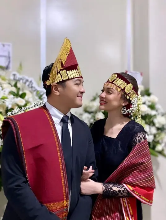 Dalam acara mangadati, Rianti tampil anggun dalam balutan kebaya hitam dan kain ulos merah. [@riantic/@__rose_makeupartist/@meli_makeuphairdowedding]