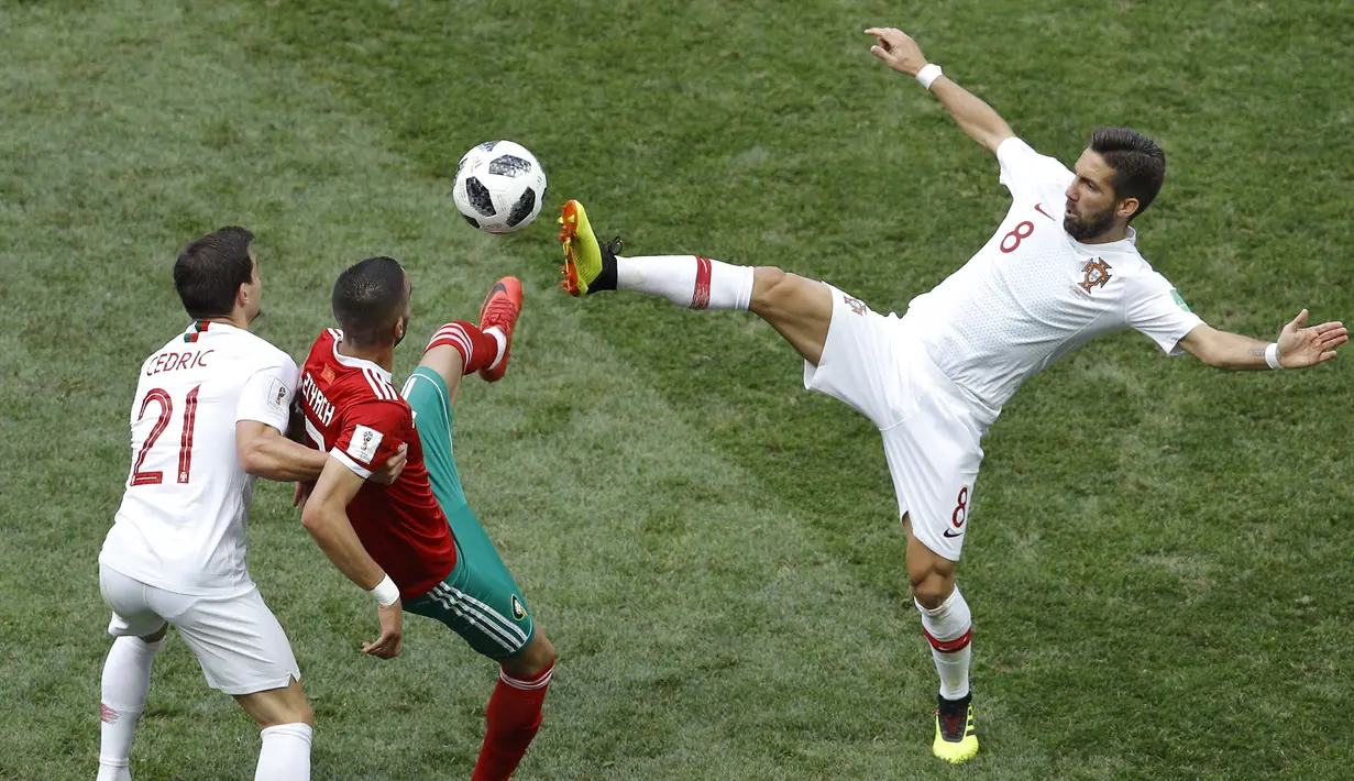 Gelandang Portugal, Joao Moutinho, berebut bola dengan gelandang Maroko, Hakim Ziyach, pada laga grup B Piala Dunia di Stadion Luzhniki, Moskow, Kamis (20/6/2018). Portugal menang 1-0 atas Maroko. (AP/Victor Caivano)