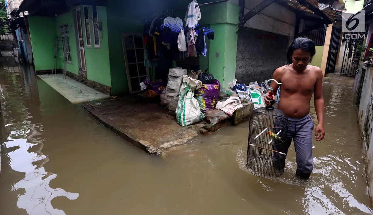 Warga melintasi banjir di permukiman Jati Padang, Jakarta, Kamis (30/11). Banjir yang terjadi tersebut akibat tanggul darurat di Kali Pulo jebol karena genangan air yang cukup deras dan membanjiri permukiman sekitar. (Liputan6.com/Johan Tallo)