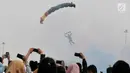 Penerjun payung bersiap mendarat saat Festival Damai Millenial Road Safety di Monas, Jakarta, Minggu (23/6/2019). Aksi puluhan penerjun payung TNI-Polri ini menjadi perhatian warga di akhir acara Festival Damai. (merdeka.com/Iqbal Nugroho)