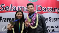 Praveen Jordan/Debby Susanto memamerkan medali emas All England 2016 di Bandara Soetta, Banten, Rabu (16/3/2016). Praveen/Debby menjadi juara usai mengalahkan pasangan Denmark, Joachim Fischer Nielsen/Christinna Pedersen. (Liputan6.com/Helmi Fithriansyah)