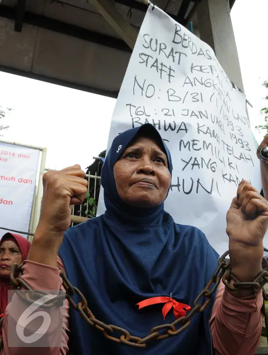 Warga saat mengelar aksi mengikat tangannya dengan rantai di kawasan sungai bambu, Jakarta Utara, Rabu (3/2). Dalam aksi mereka menolak pengosongan rumah negara secara paksa terhadap 6 rumah negara. (Liputan6.com/Helmi Afandi)