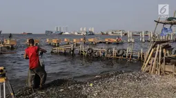Pekerja menyelesaikan pondasi dermaga di Muara Angke, Jakarta Utara, Rabu (3/7/2019). Pembangunan dermaga tersebut untuk melindungi kapal-kapal yang bersandar di dermaga dari hantaman ombak besar. (Liputan6.com/Faizal Fanani)