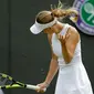 Petenis Denmark Caroline Wozniacki berusaha mengusir semut terbang ketika melawan petenis Rusia, Ekaterina Makarova pada babak kedua Wimbledon 2018 di All England Club, London, Rabu (4/7). Wozniacki tersingkir dengan skor 4-6, 6-1, 5-7. (AP/Ben Curtis)