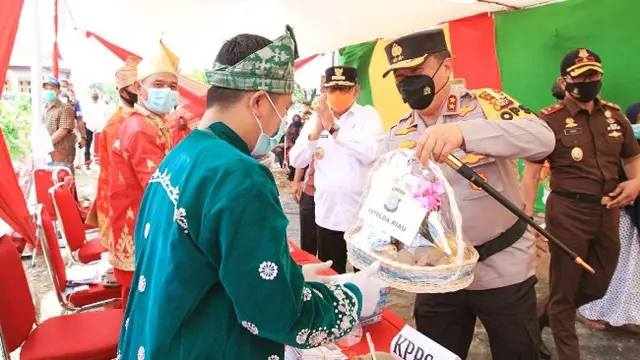 Kapolda Riau Irjen Agung memberikan bingkisan kepada petugas TPS karena telah menerapkan protokol kesehatan.