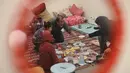 Lonjakan pengungsian itu terjadi hanya dalam beberapa hari sejak pertempuran kembali pecah di wilayah Lebanon. Tampak dalam foto, seorang wanita pengungsi yang tinggal bersama keluarganya di ruang kelas sekolah, setelah melarikan diri dari serangan udara Israel di pinggiran selatan Beirut, Lebanon, duduk untuk berbuka puasa bersama, pada 7 Maret 2026. (Ibrahim AMRO/AFP)