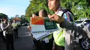 Petugas polisi menunjukkan stiker bergambar bendera Indonesia dan Arab Saudi selama persiapan menyambut kedatangan Raja Salman bin Abdulaziz di Nusa Dua, Bali (2/3). (AFP Photo / Sonny Tumbelaka)