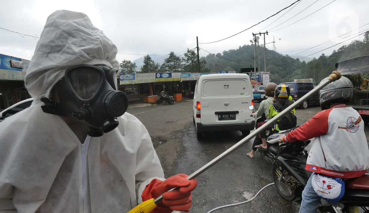 Anggota Batalyon B Brimob Cipanas melakukan penyemprotan disinfektan saat penyekatan arus lalu lintas di kawasan Ciloto, Cianjur, Jawa Barat, Jumat (17/4/2020). Penyemprotan yang dilakukan selama 20 hari tanpa henti ini untuk mencegah penyebaran virus corona COVID-19. (merdeka.com/Arie Basuki)