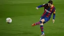 Striker Barcelona, Lionel Messi, menendang bola saat melawan Levante pada laga Liga Spanyol di Stadion Camp Nou, Senin (14/12/2020). Barcelona menang dengan skor 1-0. (AFP/Lluis Gene)