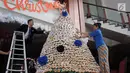 Karyawan membuat pohon Natal dari susunan donat di lobby hotel Dafam Semarang, Rabu (12/12). Pohon Natal setinggi 3 meter untuk menyambut Natal tersebut terdapat 2000 buah kue donat. (Liputan6.com/Gholib)