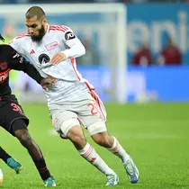 Pemain Bayer Leverkusen, Jeremie Frimpong, berebut bola dengan pemain Union Berlin, Aissa Laidouni, pada laga Bundesliga di Bay Arena, Minggu (12/11/2023). (AFP/Ina Fassbender)