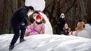 Seorang pria dan seorang anak yang mengenakan masker bermain salju di taman umum saat pakan liburan Tahun Baru Imlek di Beijing, China, Kamis (26/1/2023). (AP Photo/Mark Schiefelbein)