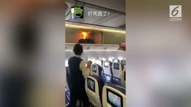 Video menunjukkan seorang pramugari dan penumpang pesawat yang mencoba memadamkan api.