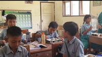 Para siswa di SMPN 1 Kragan, Kabupaten Rembang, Jawa Tengah tengah menyantap makan bergizi gratis yang disediakan pemerintah. (Liputan6.com/Arief Pramono)