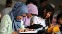 Sejumlah pelamar mengisi berkas lamaran saat menghadiri Job for Career di Stadion Gelora Bung Karno Jakarta, Rabu (30/9/2015). Tingginya angka pencari kerja menjadikan bursa kerja ramai peminat. (Liputan6.com/Helmi Fithriansyah)