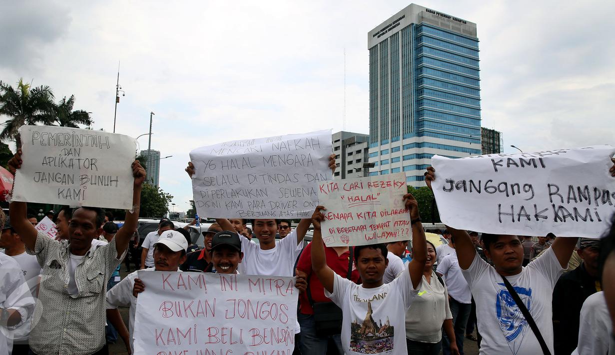 Sejumlah orang membawa poster saat menggelar unjuk rasa di depan Gedung MPR/DPR, Jakarta, Senin (27/2). Diantaranya kebijakan dilarangnya beroperasi sebagai transportasi online di beberapa tempat. (Liputan6.com/Johan Tallo)