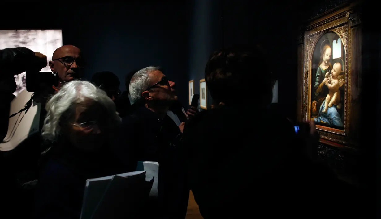 Awak media melihat lukisan "Benois Madonna" karya Leonardo Da Vinci yang dipajang di museum Louvre, Paris, Selasa (22/10/2019). Ada 160 karya dalam pameran 500 tahun wafatnya Leonardo da Vinci yang diharap dapat menarik setengah juta pengunjung saat ditutup pada 24 Februari 2020. (AP/Thibault Camus)