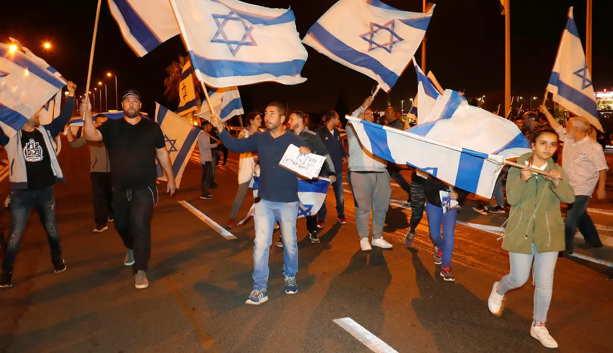 Warga berdemonstrasi menentang gencatan senjata dengan Hamas di Kota Ashkelon Selatan, Israel, Rabu (14/11). PM Israel Benjamin Netanyahu menyetujui gencatan senjata dengan Hamas di Gaza. (JACK GUEZ/AFP)