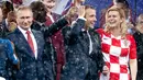 Senyum Presiden Rusia Vladimir Putin (kiri) bersama Presiden Prancis Emmanuel Macron (tengah) dan Presiden Kroasia Kolinda Grabar-Kitarovic usai laga final Piala Dunia 2018 di Stadion Luzhnik, Moskow, Rusia, Minggu (15/7). (AP Photo/Petr David Josek)
