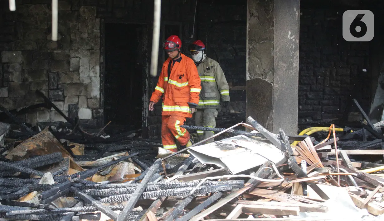 Petugas pemadam kebakaran berjalan di antara sisa kebakaran gedung Hailai di kawasan Ancol, Jakarta Utara, Selasa (5/11/2019). Tidak ada korban jiwa dalam kebakaran yang diduga  karena percikan api dari aktivitas pembongkaran yang menggunakan mesin las. (Liputana6.com/Faizal Fanani)