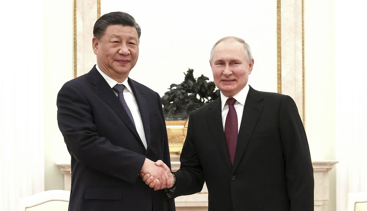 Dalam foto selebaran yang dirilis oleh Kantor Pers Kepresidenan Rusia ini memperlihatkan Presiden Rusia Vladimir Putin (kanan) dan Presiden Tiongkok Xi Jinping berjabat tangan sebelum pembicaraan mereka di Kremlin di Moskow, Senin (20/3/2023). (Russian Presidential Press Office via AP)