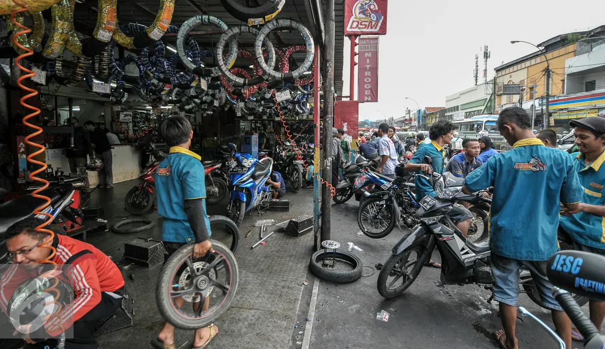Suasana bengkel motor di kawasan Pasar Minggu, Jakarta, Kamis (30/6). Jelang mudik Lebaran pekerja jasa servis motor menerima orderan dua kali lipat dari hari biasa. (Liputan6.com/Yoppy Renato)