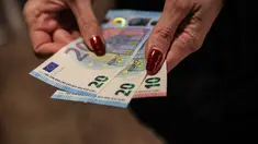 Seseorang menunjukkan uang kertas euro yang ditarik dari ATM di Sofia, Bulgaria, Kamis 1 Januari 2026, saat negara tersebut bergabung dengan serikat mata uang euro. Bulgaria resmi memasuki era baru kebijakan moneter dengan mengadopsi euro sebagai mata uang nasional. (AP Photo/Valentina Petrova)