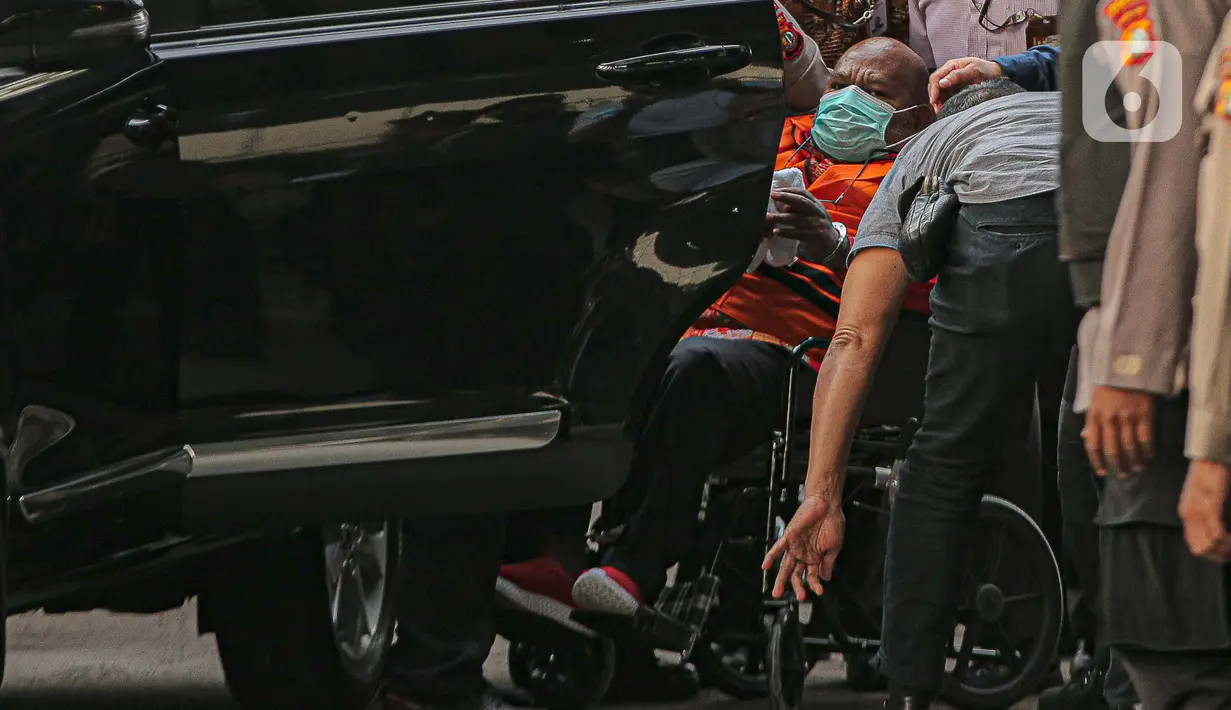 Tersangka kasus dugaan korupsi pembangunan infrastruktur di Provinsi Papua Lukas Enembe  Lukas Enembe dibawa dari RSPAD Gatot Subroto untuk menjalani pemeriksaan di Gedung Merah Putih KPK, Jakarta, Kamis (12/1/2023). Lukas yang masih mengenakan rompi oranye dan tangannya diborgol turun dari mobil KPK dan langsung menggunakan kursi roda. (Liputan6.com/Faizal Fanani)
