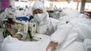 Pekerja menjahit bahan untuk digunakan membuat pakaian antivirus di pabrik garmen Zhejiang Ugly Duck Industry, di Wenzhou, 28 Februari 2020. Wabah virus corona di China membuat produsen pakaian itu mulai memproduksi baju hazmat yang banyak diburu orang untuk melindungi dirinya. (NOEL CELIS/AFP)
