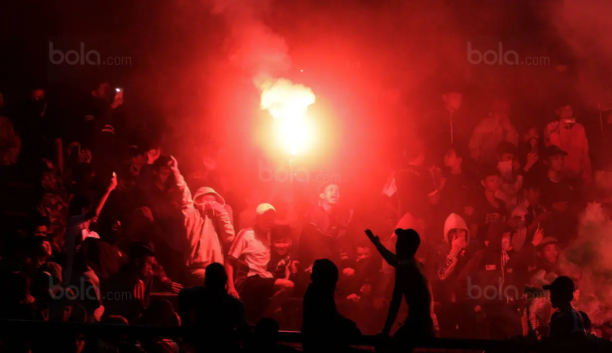 Suporter Persib menyalakan flare usai pertandingan melawan PSM pada laga Piala Presiden di Stadion GBLA, Bandung, Jumat (26/1/2018). Persib takluk 0-1 dari PSM. (Bola.com/M Iqbal Ichsan)