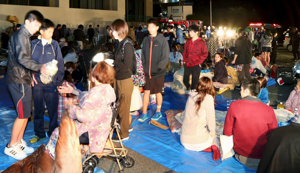 Warga berkumpul di depan sebuah gedung kantor saat gempa bumi 6,4 SR di Mashiki, Prefektur Kumamoto, Jepang selatan, Kamis (14/4). Menurut laporan media Jepang, sekitar 23.000 orang berlindung di sekitar 350 lokasi di Prefektur Kumamoto. (REUTERS/Kyodo)