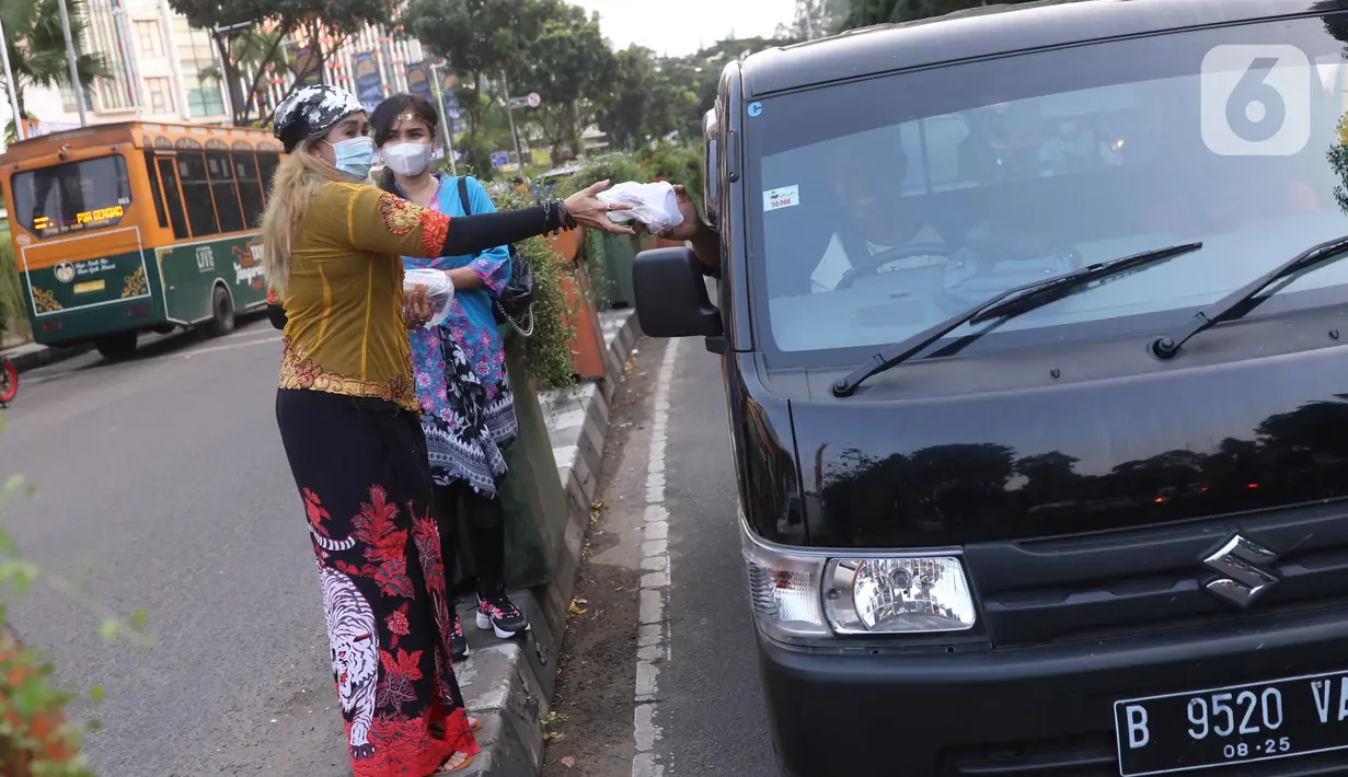 Sejumlah perempuan dengan mengenakan kebaya membagikan takjil untuk berbuka puasa bagi pengendara yang melintas di kawasan Tangerang, Banten, Rabu (21/4/2021). Pembagian takjil dengan mengenakan kebaya tersebut untuk merayakan Hari Kartini. (Liputan6.com/Angga Yuniar)