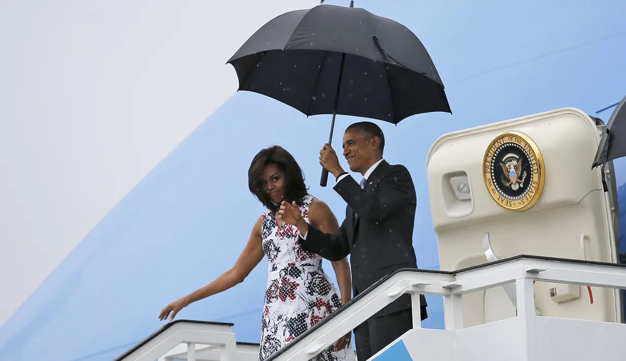 Presiden AS Barack Obama dan istrinya Michelle saat turun dari pesawat Air Force One setibanya di Bandara Internasional Havana, Kuba, Minggu (20/3). Kunjungan Obama ini yang pertama dilakukan seorang presiden AS sejak 88 tahun lalu. (REUTERS/stringer)
