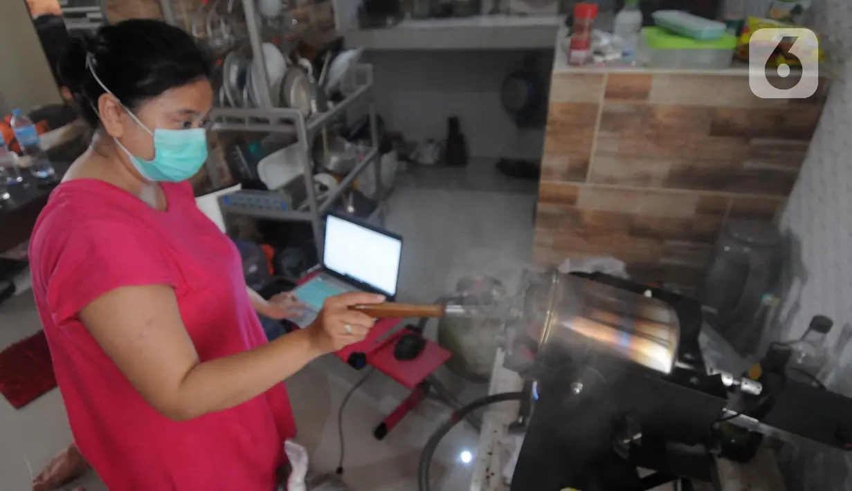 Ibu Rythia (35) menggiling kopi yang sudah diroastingnya di rumahnya di Nusa Dua, Bali (7/9/2021). Dibandingkan gajinya sebagai pekerja sektor pariwisata yang dirumahkan  saat ini hanya Rp 1 juta. (merdeka.com/Arie Basuki)