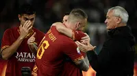 Gelandang AS Roma, Daniele De Rossi, memeluk rekannya usai melawan Parma pada laga Serie A di Stadion Olympic, Roma, Minggu (26/5). Laga ini perpisahan bagi De Rossi dan AS Roma setelah 18 tahun. (AFP/Filippo Monteforte)