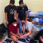 Pria yang menyamar menjadi wanita (masker putih) saat ditangkap Polda Riau karena mengancam menyebar video call sex. (Liputan6.com/M Syukur)
